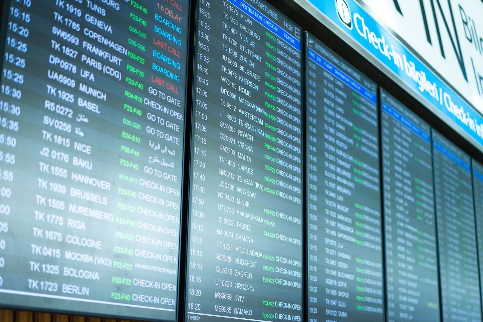 Flight information screens showing departures in an airport terminal